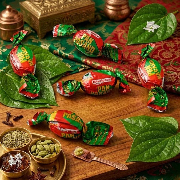 Desipan Pan Pasand Gold candies individually wrapped in red and green foil, featuring paan leaves and spices.