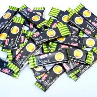 Desipan Black Mango Almond candies, individually wrapped, featuring a sweet and tangy exotic mango flavor with a hint of almond.