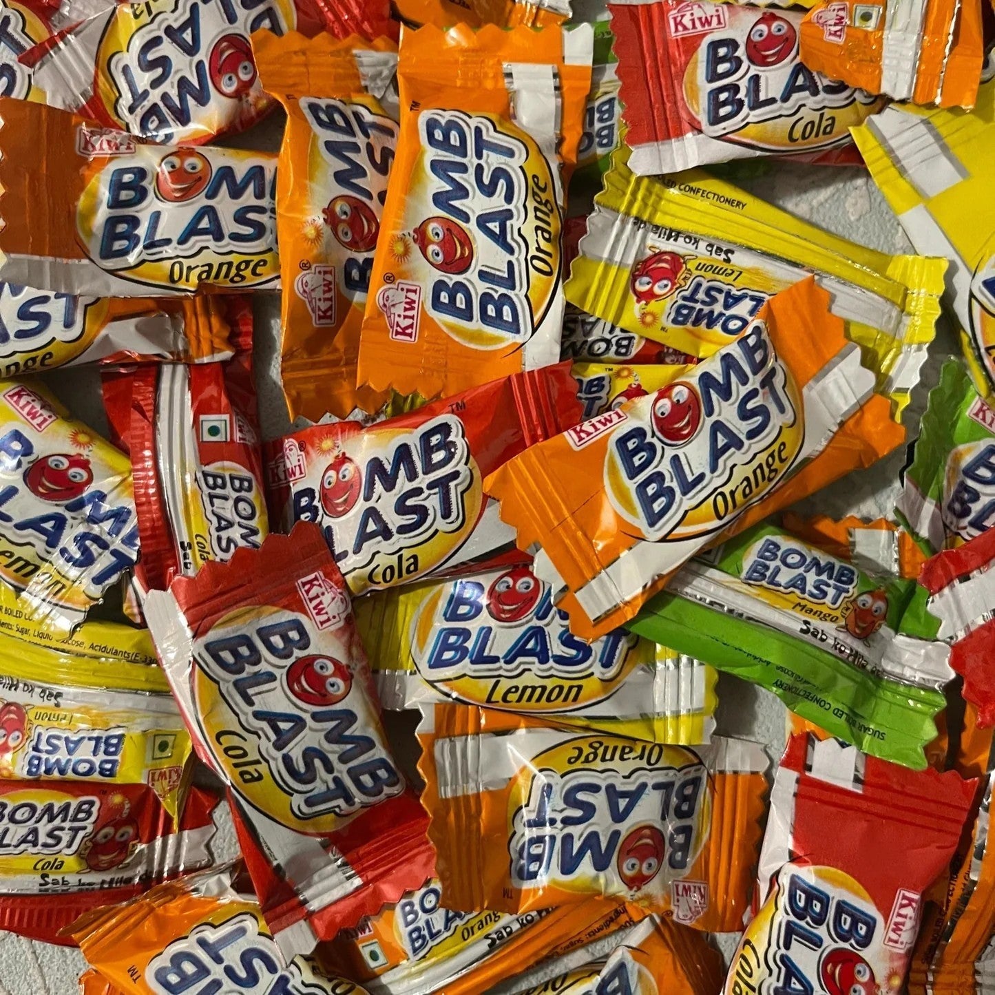 Assorted fruit and cola flavored Bomb Blast candies by Desipan, individually wrapped with cartoon characters.