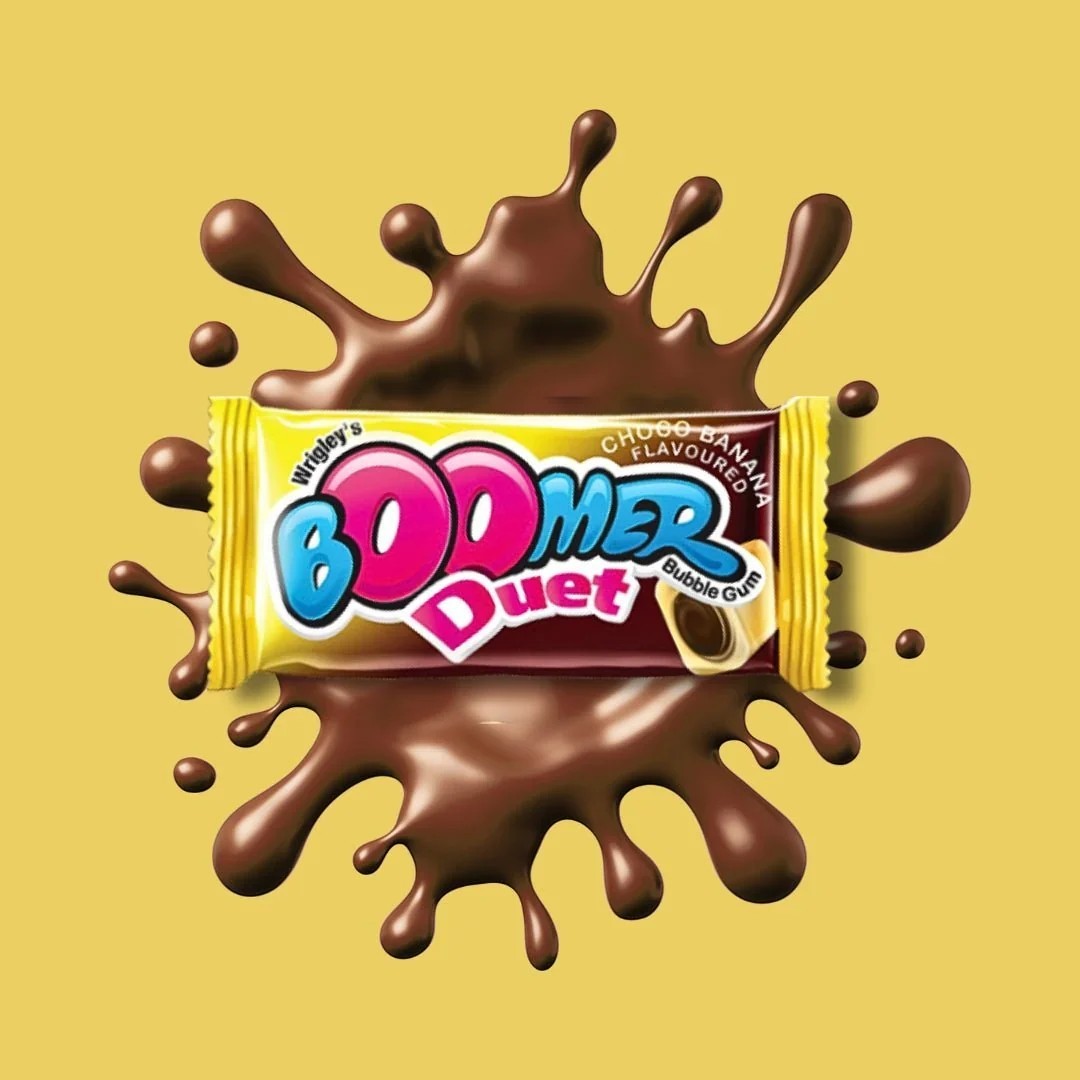 Desipan Wrigley's Boomer Duet bubble gum with chocolate and banana flavor, surrounded by chocolate splashes.