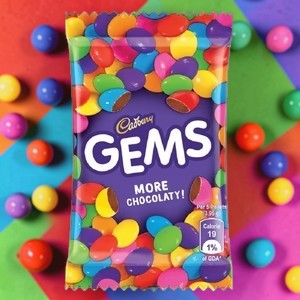 Desipan Cadbury Gems chocolate candies in a colorful wrapper, featuring small, candy-coated milk chocolates.