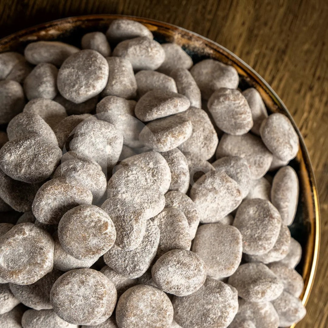 Desipan chocolate covered licorice pebbles candy, dusted with sweet powder.