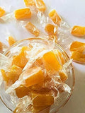 Desipan individually wrapped golden citrus hard candies in a glass bowl.