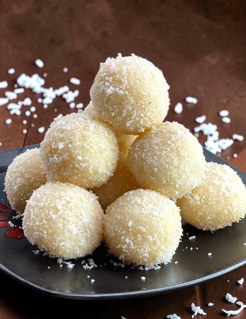 Desipan Coconut Snowball Cookies are small, round, white treats coated in shredded coconut.