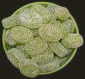 Desipan green fruit flavored hard candies dusted with powdered sugar and embossed patterns.