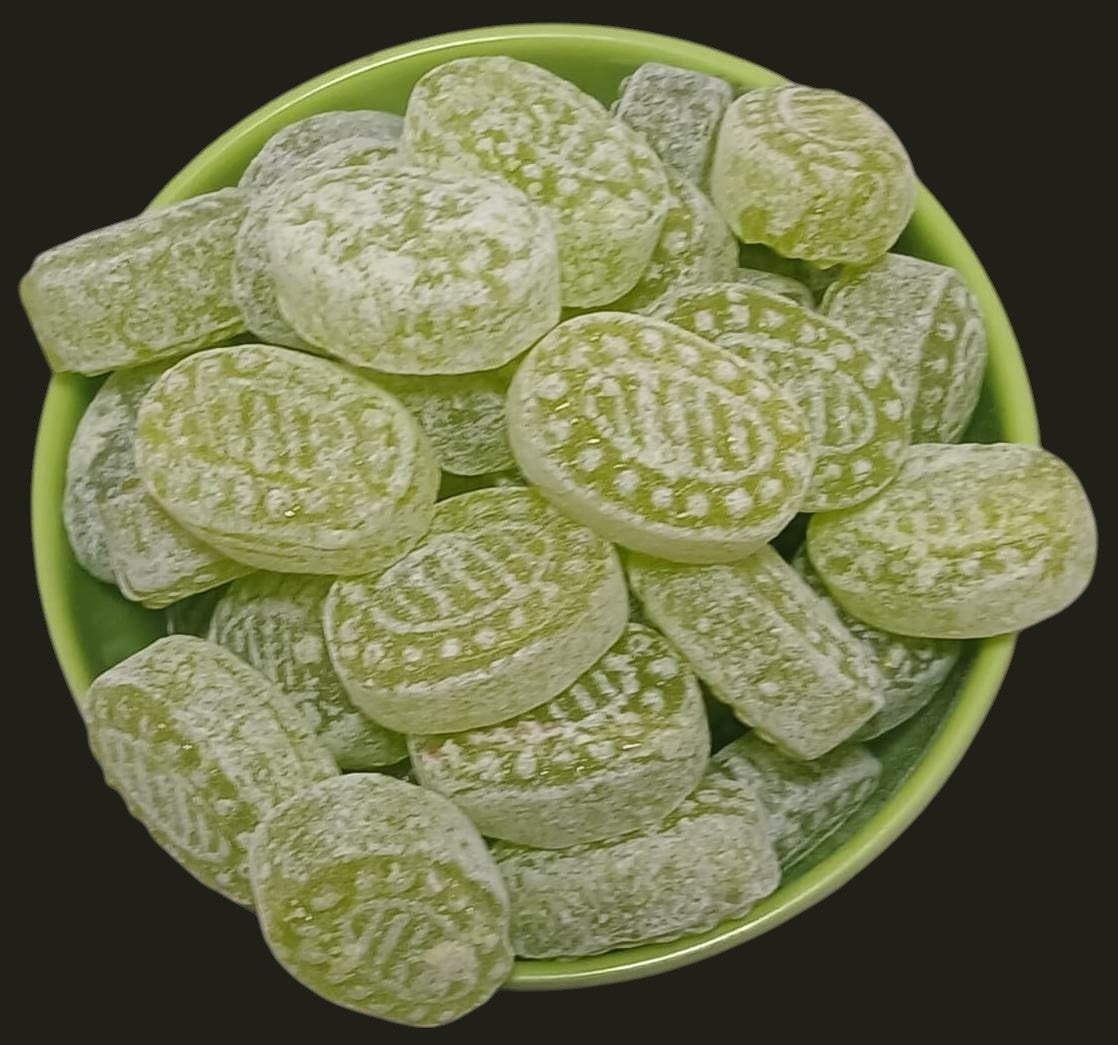 Desipan green fruit flavored hard candies dusted with powdered sugar and embossed patterns.