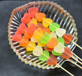 Desipan assorted fruit flavored gummy heart lollipops coated in sugar, served in a glass dish.
