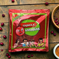 Desipan Hajmola Anardana digestive candy pouch featuring a cartoon pomegranate and four people. Tangy and sweet.