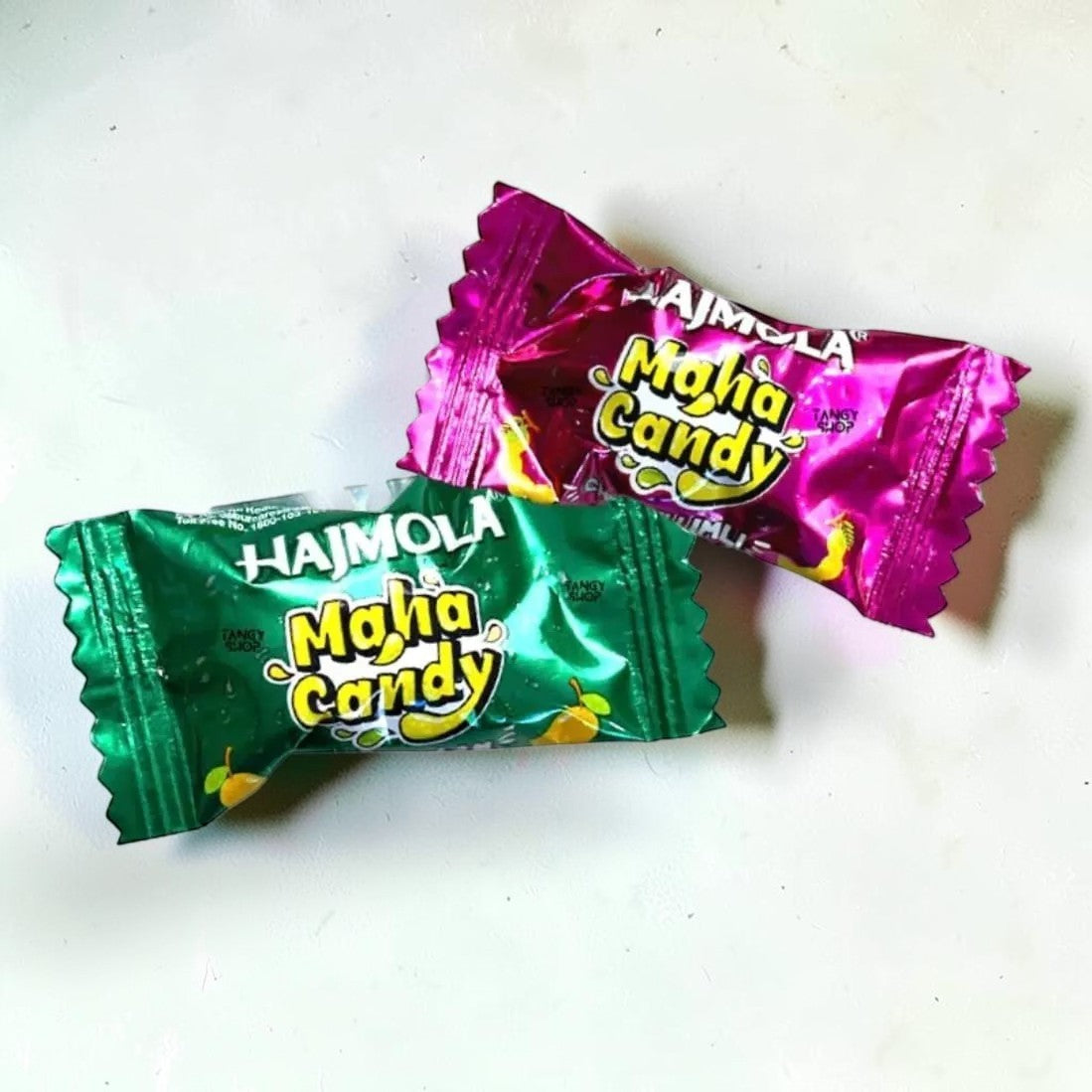 Desipan Hajmola Maha Candy in green and pink foil wrappers, offering a tangy sweet and sour flavor.