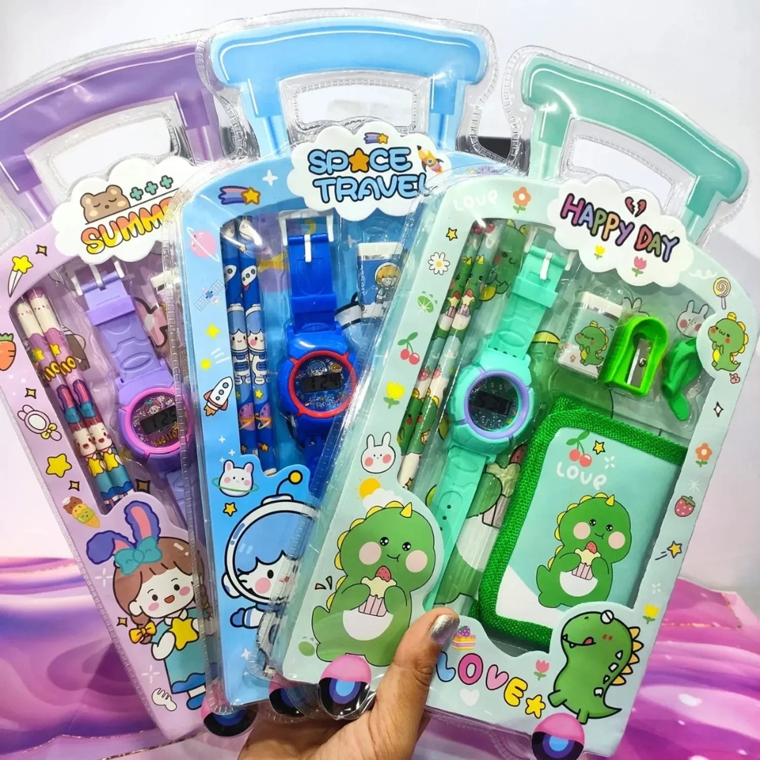 Desipan Kids digital watch and stationery sets in purple, blue, and green featuring cartoon characters like dinosaurs, astronauts, and bunnies.