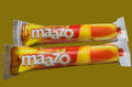 Desipan Maazo Mango Flavored Candy Sticks, individually wrapped, orange and yellow packaging, on a keyboard.