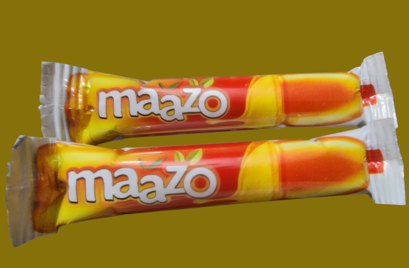 Desipan Maazo Mango Flavored Candy Sticks, individually wrapped, orange and yellow packaging, on a keyboard.