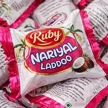 Desipan Ruby Nariyal Laddoo coconut sweet confectionery, individually wrapped in pink and white packaging with coconut imagery.