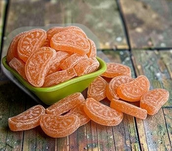 Desipan orange slice candies, shaped like segments and dusted with sugar, offering a tangy citrus flavor.