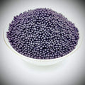 Desipan organic fertilizer granules in dark purple, slow-release pellets for plant health and growth.