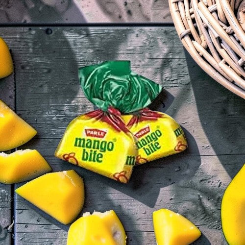 Desipan Parle Mango Bite candies, individually wrapped in yellow packaging with green tops, offering a tropical mango flavor.