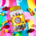 Desipan Pim Pom lollipops in a clear jar with a yellow lid. Assorted fruit flavors.