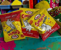 Desipan Rinkas Chatjola candy packets with yellow and red wrappers featuring a playful elephant design.