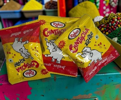 Desipan Rinkas Chatjola candy packets with yellow and red wrappers featuring a playful elephant design.