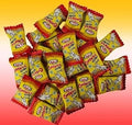 Pile of Rola's Chholla Zzest Candy individually wrapped in yellow and red packaging. Desipan.