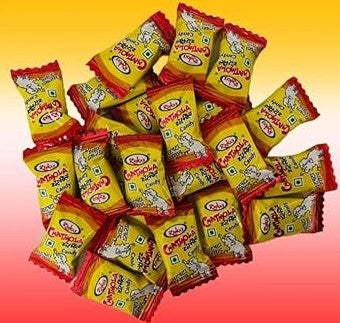 Pile of Rola's Chholla Zzest Candy individually wrapped in yellow and red packaging. Desipan.