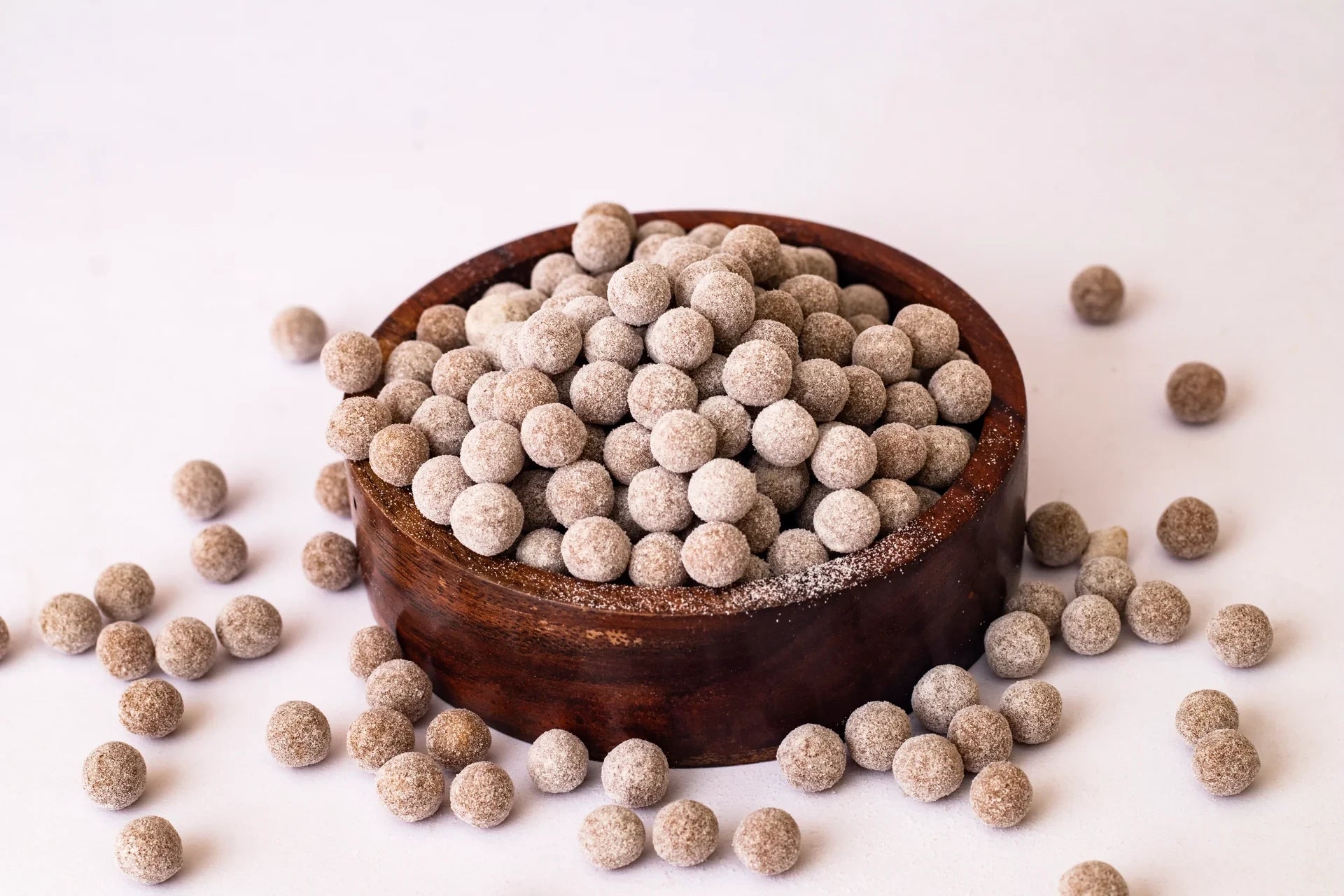 Desipan Traditional Indian Sweet Snack Balls, light brown tapioca pearls coated in sugar, in a wooden bowl.