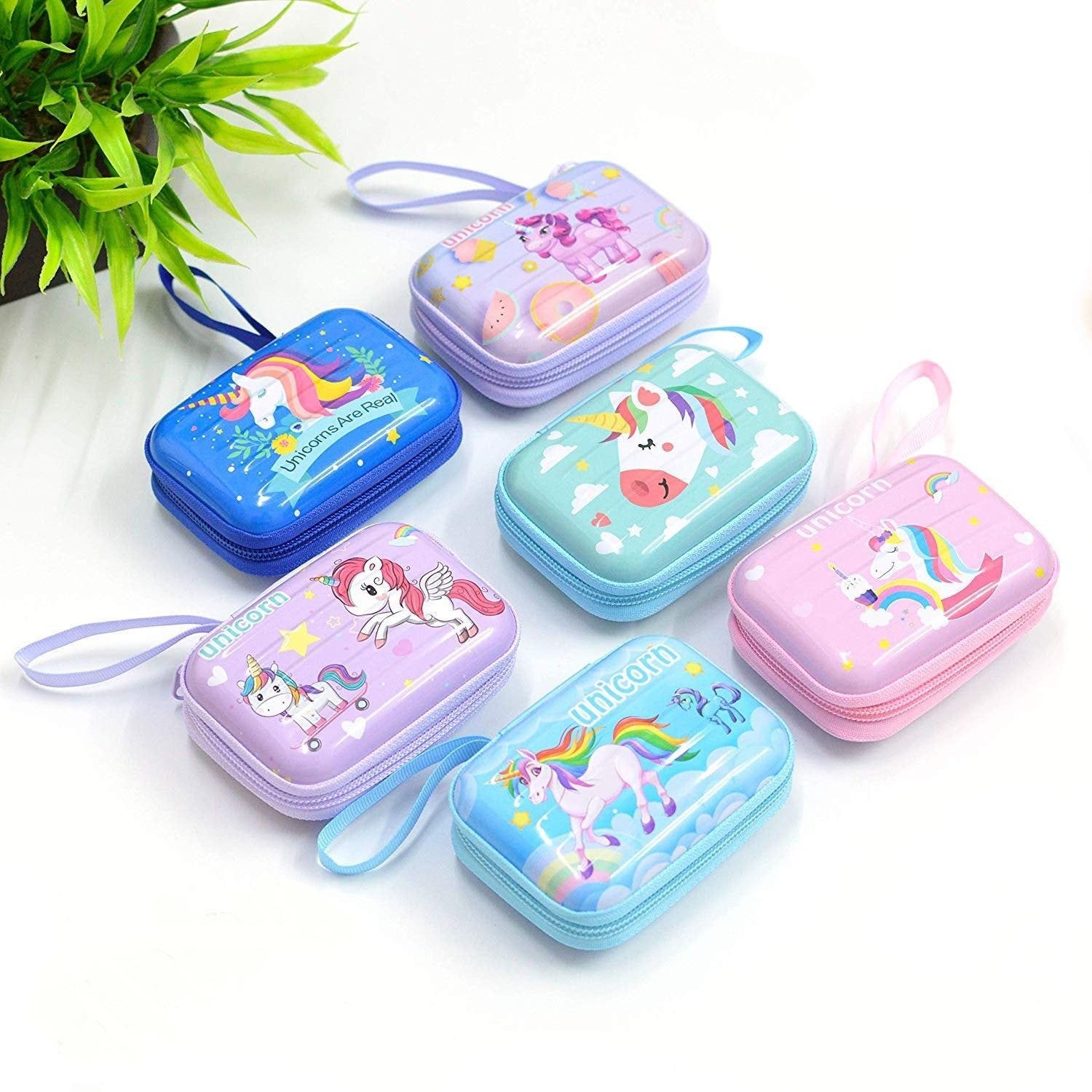 Desipan collection of zippered coin purses featuring colorful unicorn and rainbow designs on pastel blue, purple, pink, and green metal cases with wrist straps.